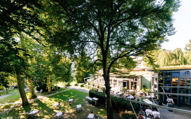 Im Garten unter den Bäumen vom Stadthauspark - Park Hotel Winterthur